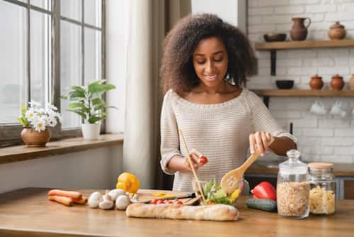 Curly haired woman preparing vegan diet