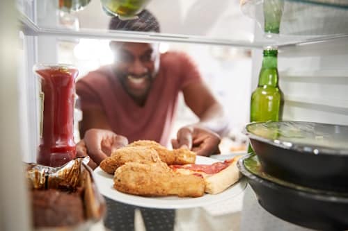 Man getting junk foods from refrigerator