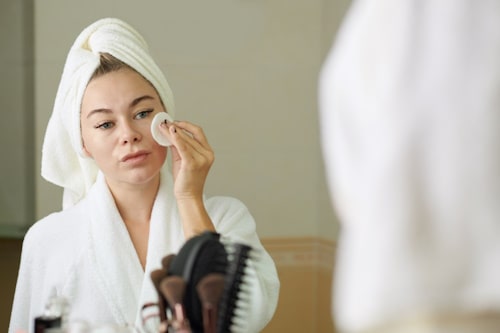 Woman using expensive face skin care product