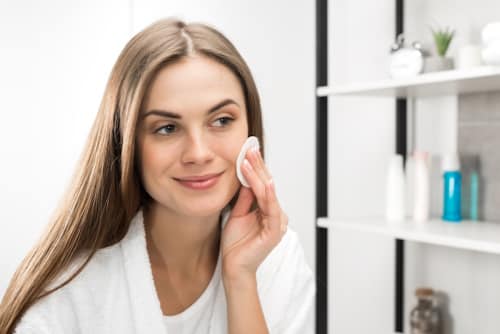 Pretty woman cleansing her face