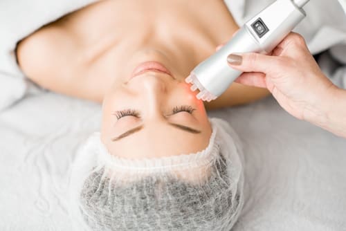 Top view of person getting face light therapy