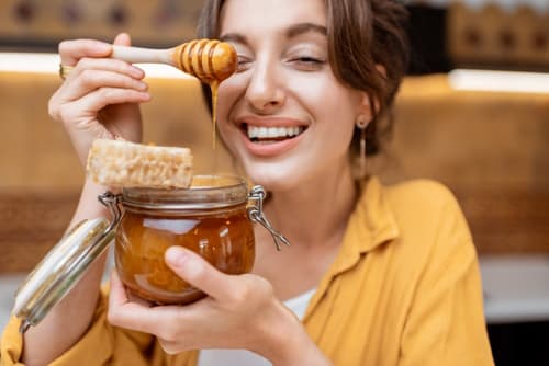 Woman happily eating honey