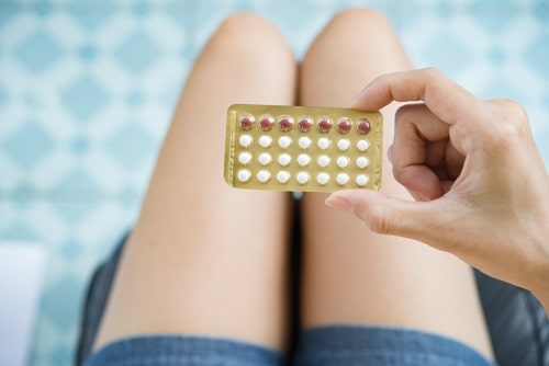Oral contraceptives held by person