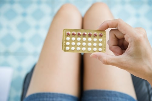 Female legs covered by contraceptive pills