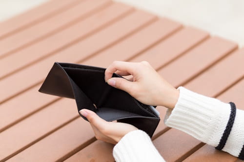 Image of person holding and opening empty wallet