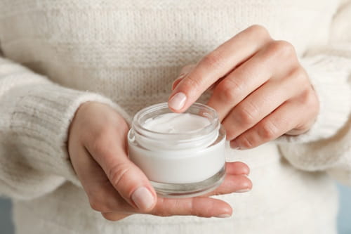 Woman holding cream with snail mucin