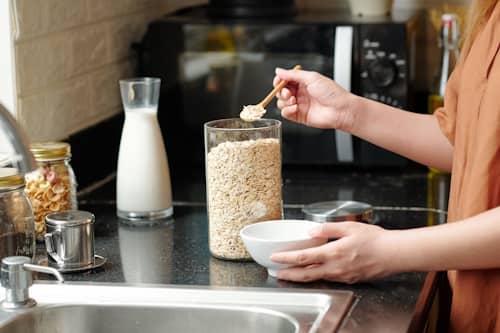 Person taking natural oats from jar