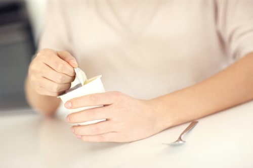 Woman opening commercial yogurt 