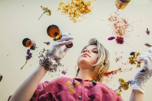 Woman making various herbal skin serums