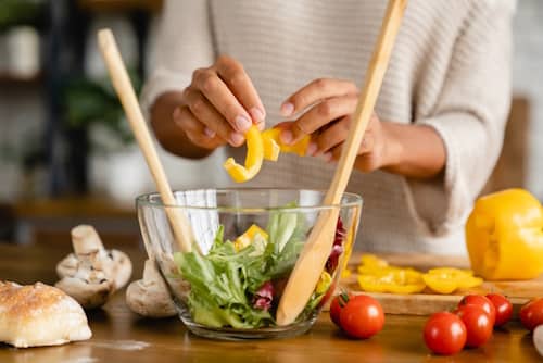 Woman preparing vegan meal with vegetables