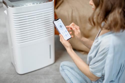 Woman using a dehumidifier