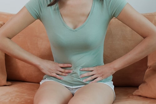 Woman sitting and holding her stomach