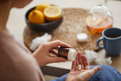 Hand of person taking prednisone from pill bottle