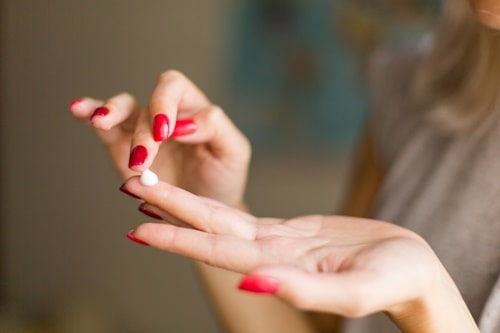 Clobetasol propionate ointment on woman's fingertips
