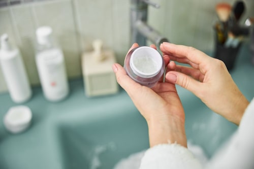 Image of face cream held by woman hands