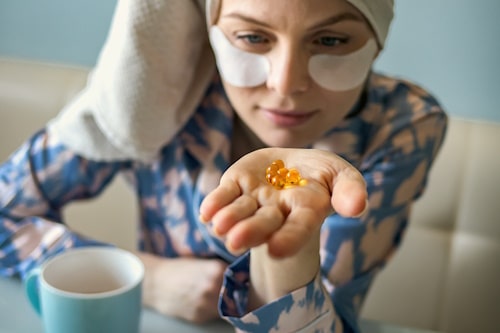 Woman holding fish oil capsules