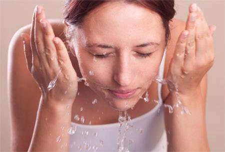 Woman rinsing face.