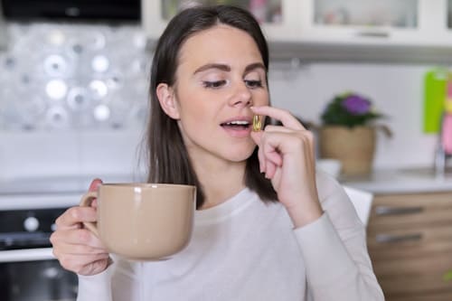 Woman taking fish oil supplement