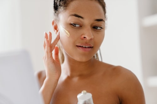 Woman applying face cream with Bakuchiol