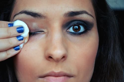 Woman removing eye makeup close up