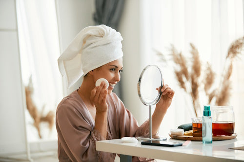 Image of woman cleaning her face with skin toner