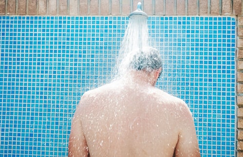 Young man having a shower after playing sports