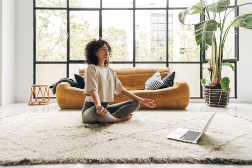 Young multiracial latina woman meditating at home