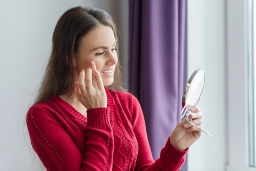 Woman putting on moisturizer