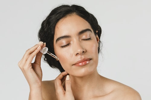 Woman putting serum to her ears