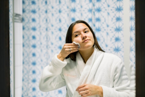 Young woman cleaning her face 