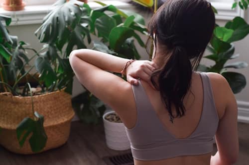 Woman rubbing sore muscles on shoulder