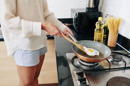 Person cooking sunny side up egg