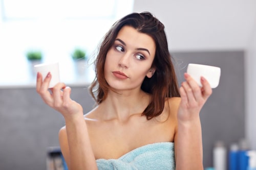 Young woman choosing skin care product
