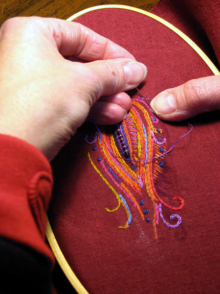 Hand stitching embroidery on red linen hoop