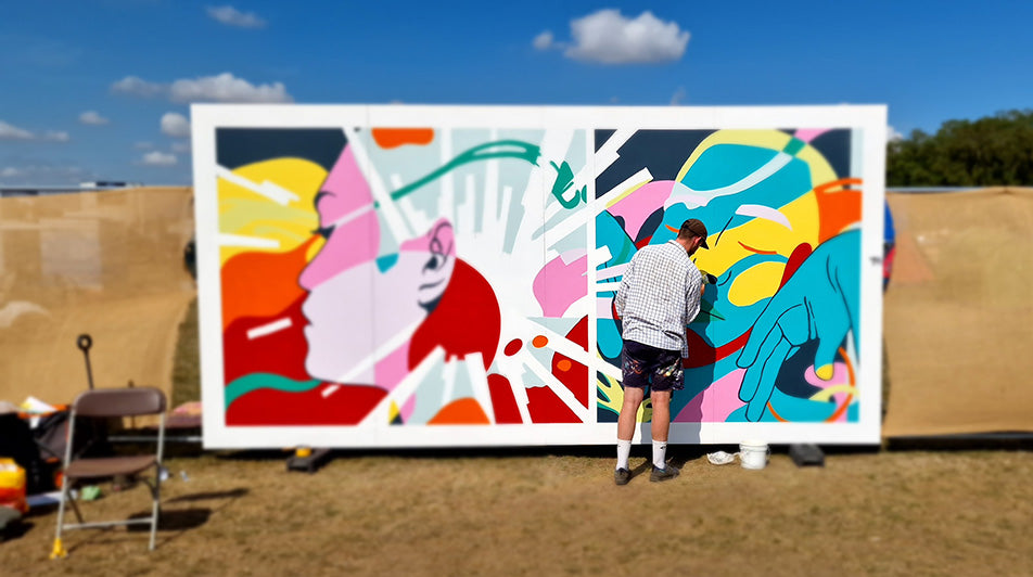 Artist painting wall at We Out Here Festival 