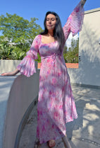 front view of model in pink watercolour flowing dress with flowing sleeves