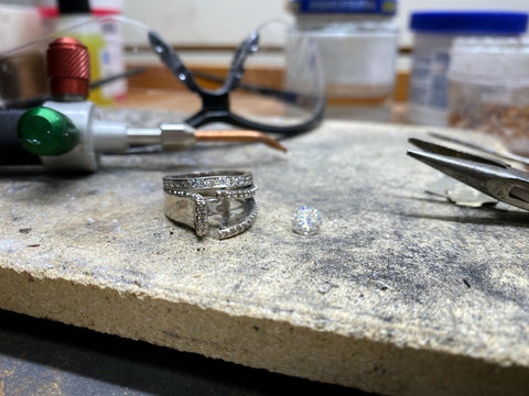 Diamond ring on a goldsmithing bench that has a cut shank and is being repaired.