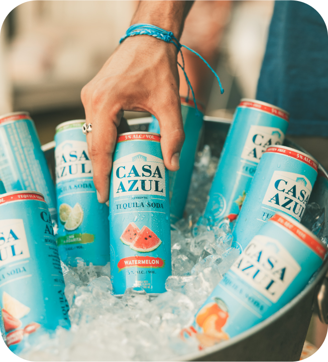 Woman grabbing a can of Casa Azul tequila soda watermelon from ice bucket