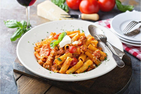 Plato de rigatoni con tomate frito y otros aderezos