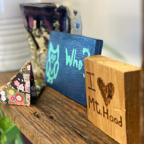 Picture of blue painted owl with the word "who" on a shelf