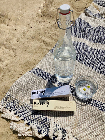 krem z filtrem mineralnym SPF30 i SPF50, na kocu na plaży w słoneczny dzień 