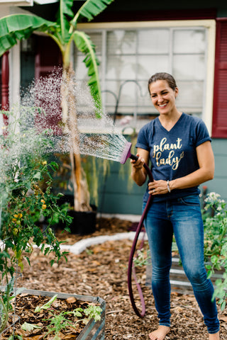 Elise of The Urban Harvest watering garden with premium watering hose.