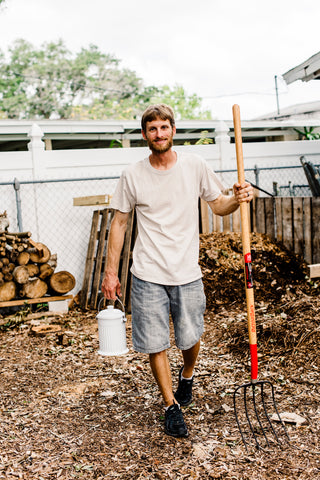 Gardener with high quality pitchfork in front of compost.