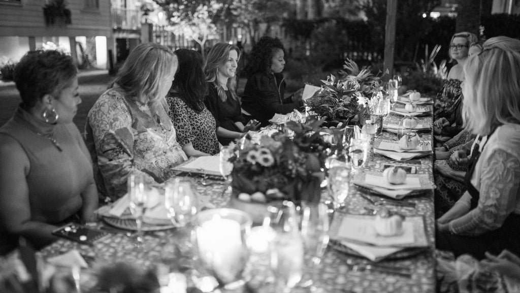 Black and white photo of women at WE Inc. outdoor dinner, image