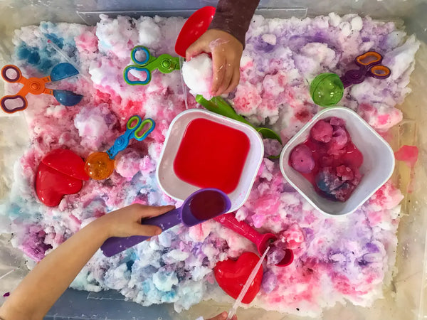 Valentine's themed sensory bin with scooping and pouring and lots of vivid color mixing.