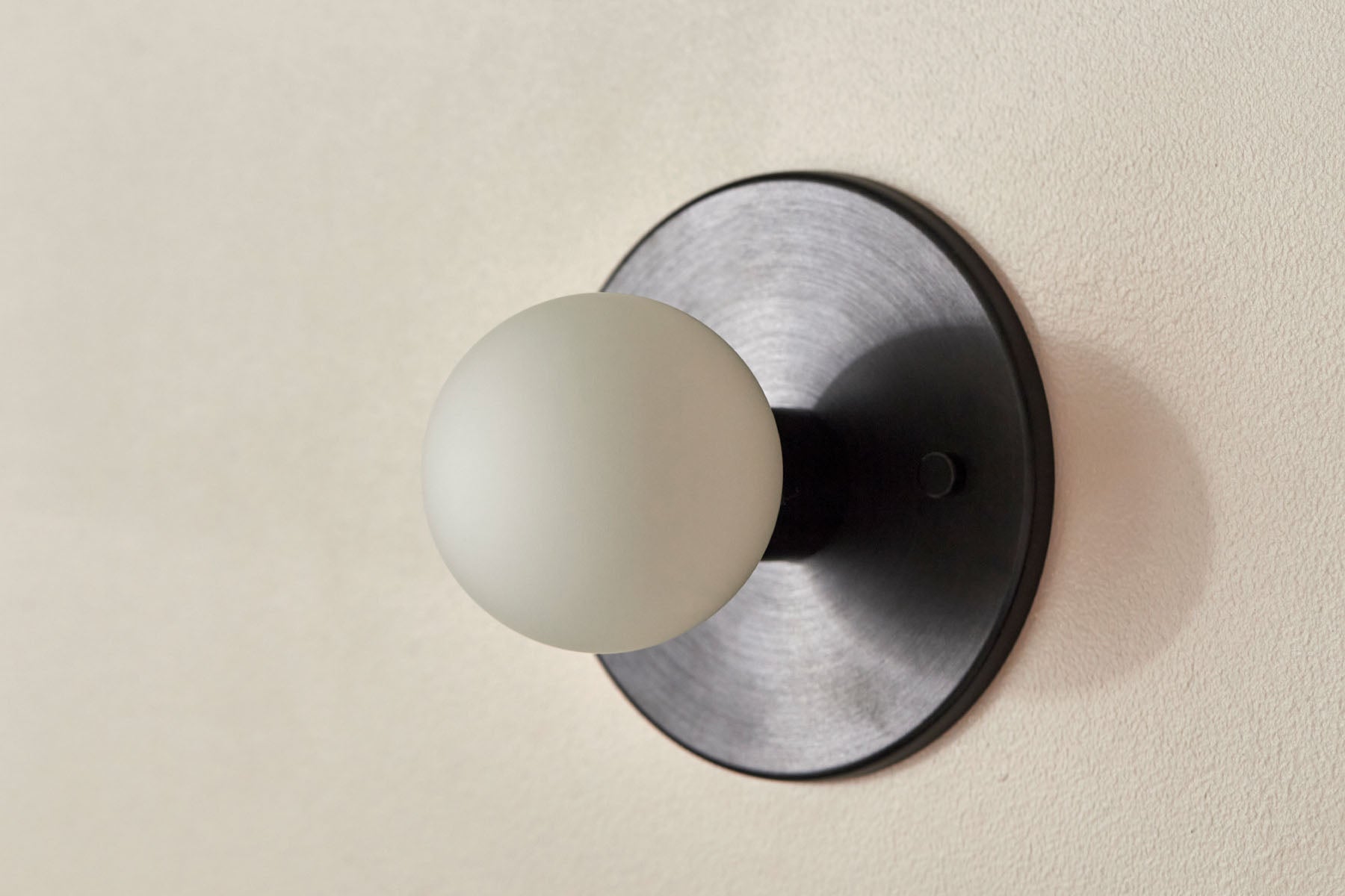 Orb Surface Sconce, Mini in Brushed Black and White Frosted. Image by Lawrence Furzey.