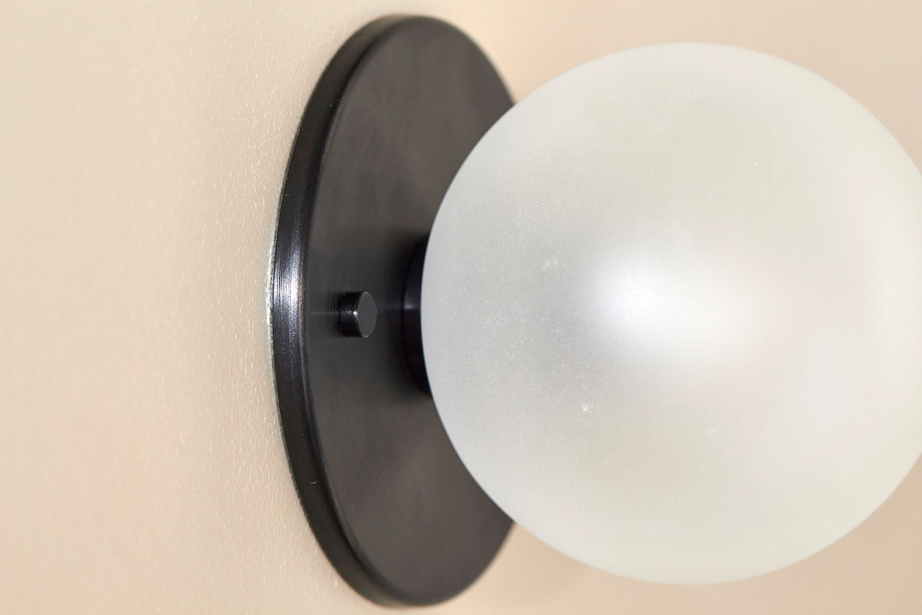 Orb Surface Sconce, Small in Brushed Black and Clear Frosted. Image by Lawrence Furzey.