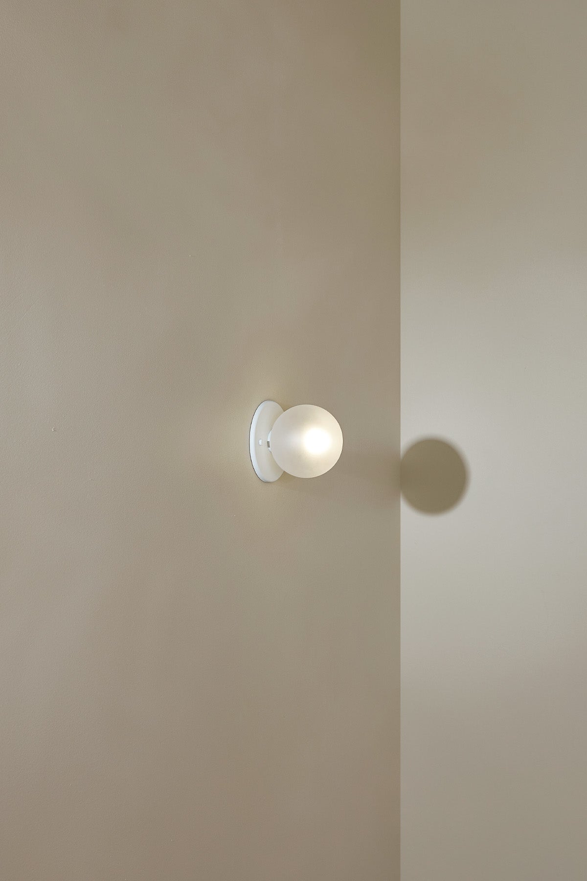 Orb Surface Sconce, Small in White Satin and Clear Frosted. Image by Lawrence Furzey.