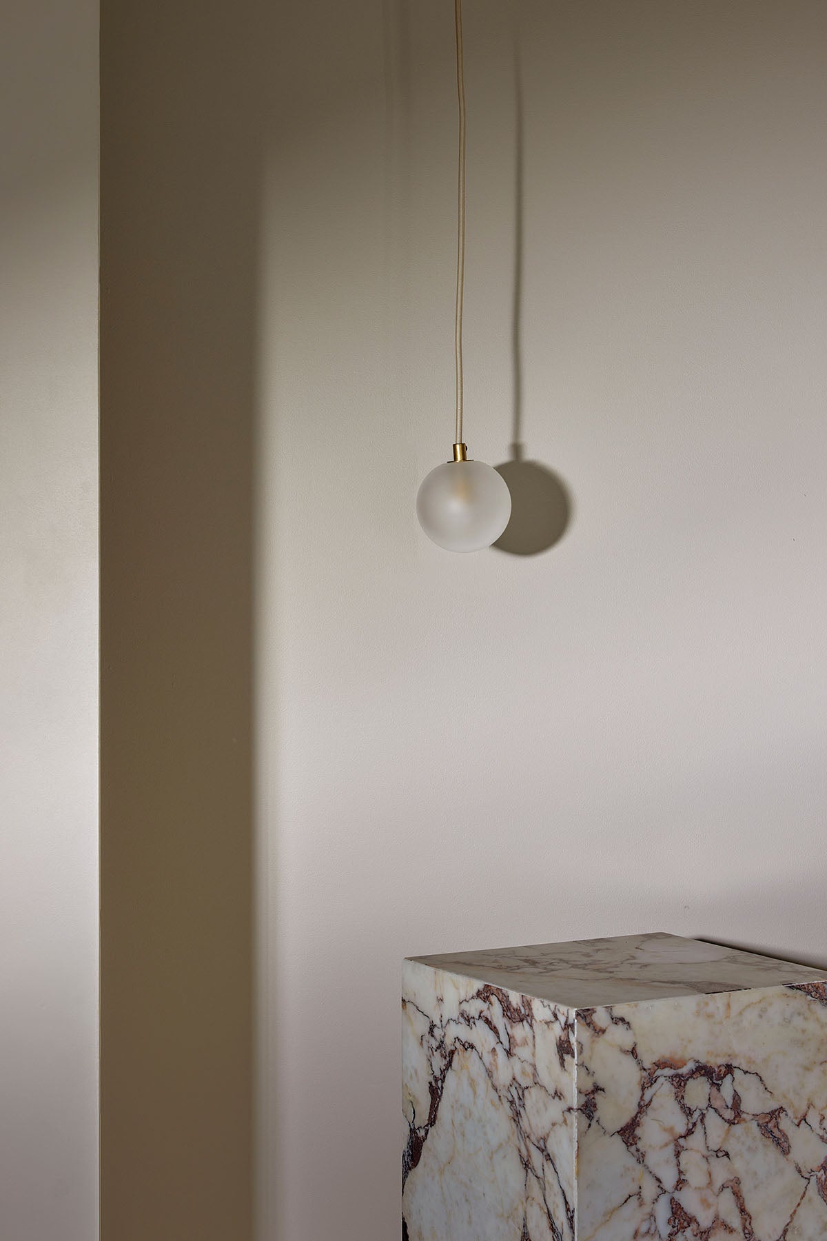 Orb Small Pendant, Solid Rod in Brass and Clear Frosted. Image by Lawrence Furzey