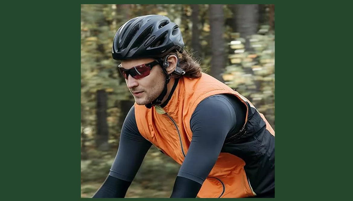 A person is cycling while wearing Sanag bone conduction headphones.